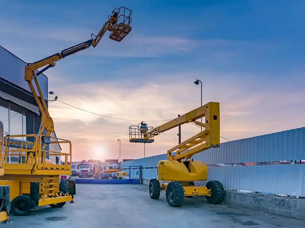 two yellow machines before a construction site