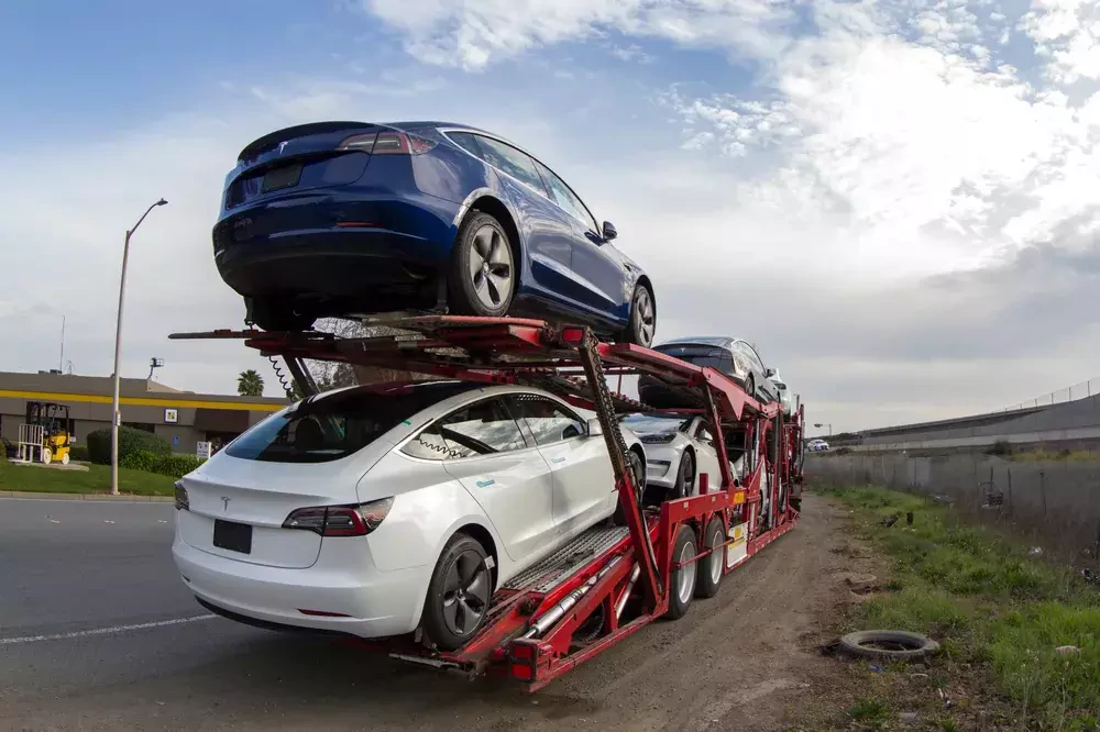 a truck delivering tesla vehicles