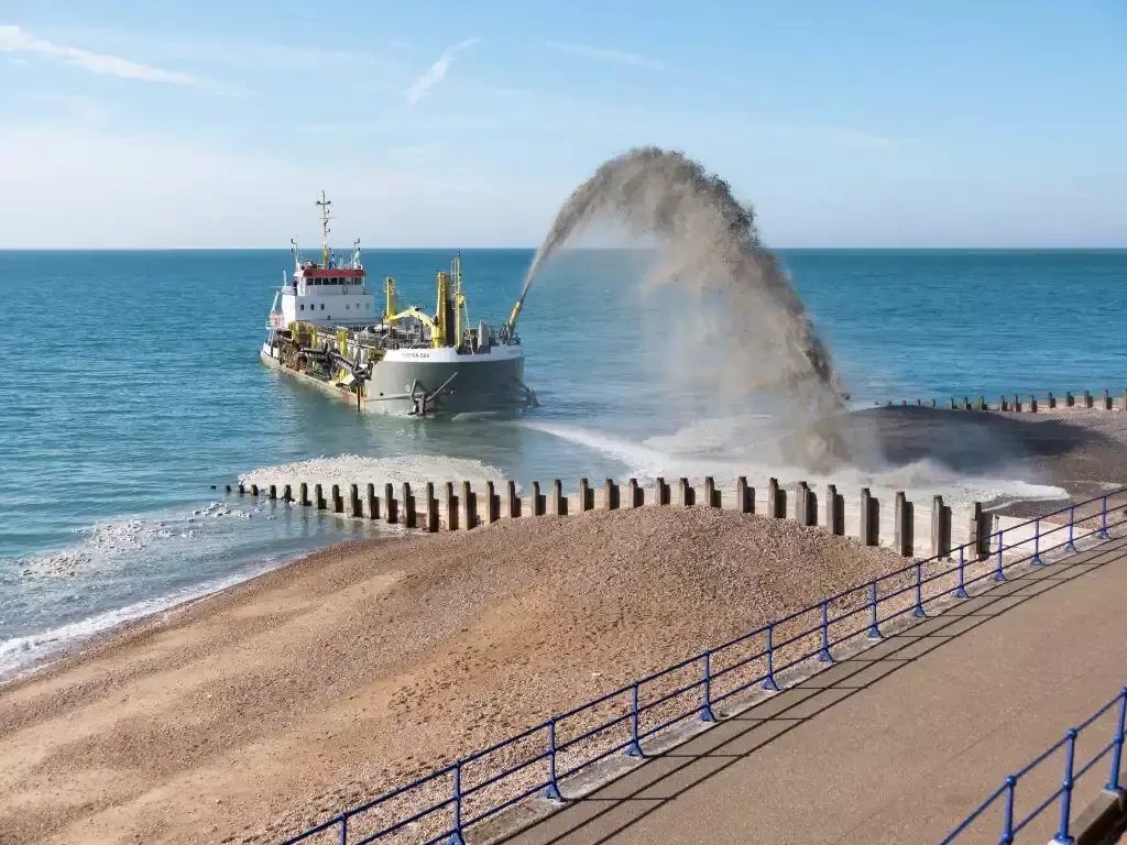 a large ship dumping sand