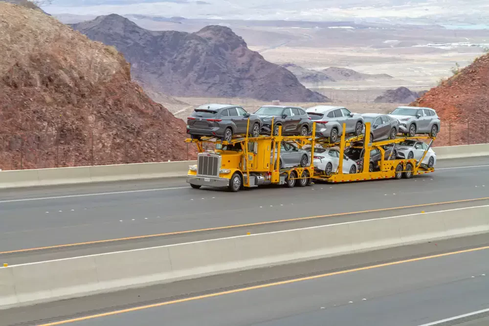 a yellow truck carrying vehicles
