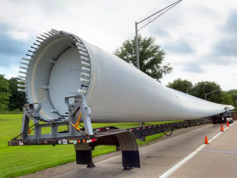 a large wind engine blade being transported on a flatbed truck