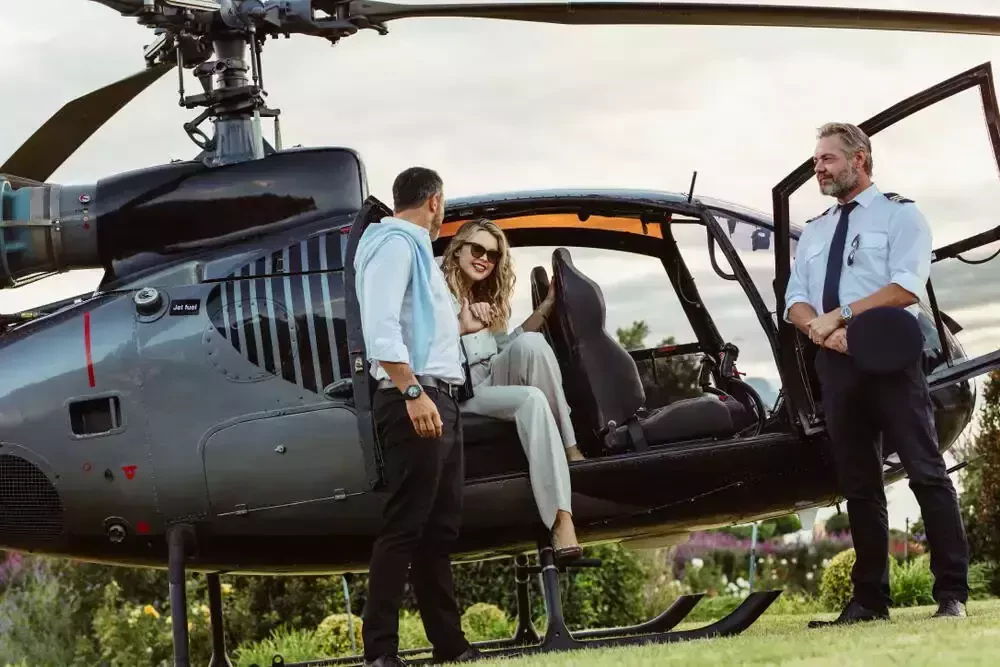 people beside a helicopter in a grassy field