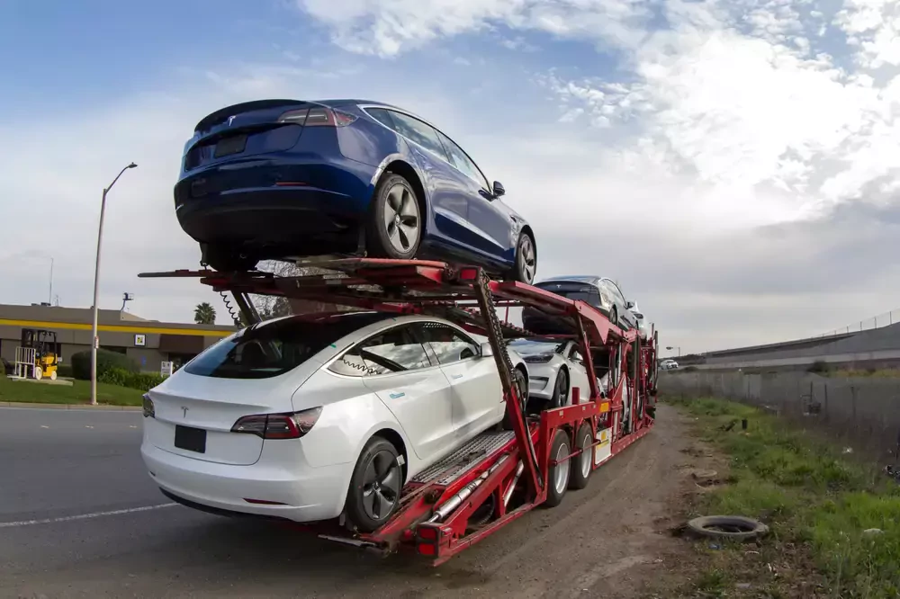 a truck delivering tesla vehicles
