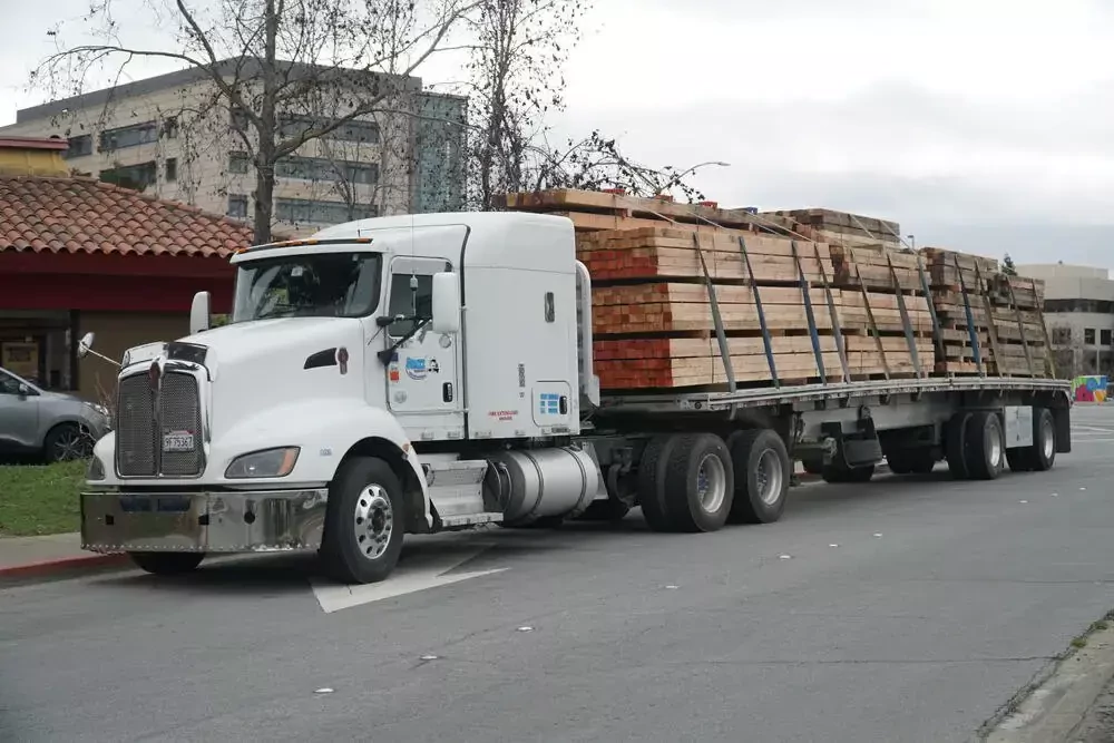 truck transporting timber along roadside