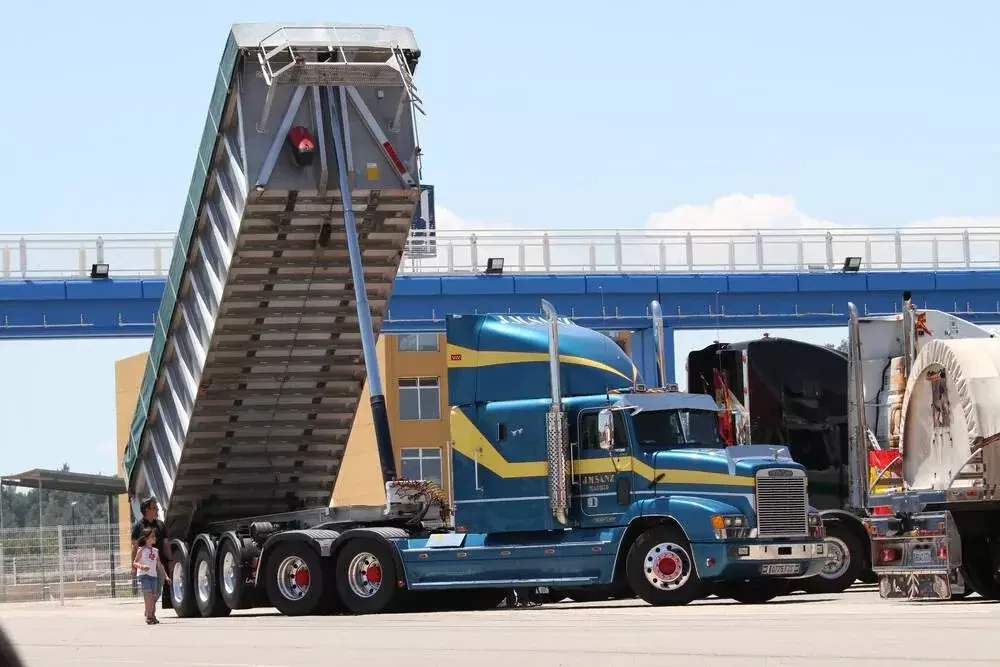 a large blue and yellow semi truck parked on the roadside