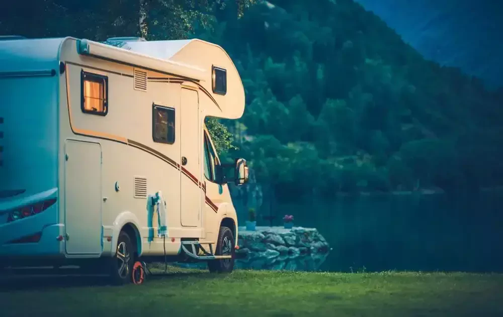 a motorhome parked by a serene lake
