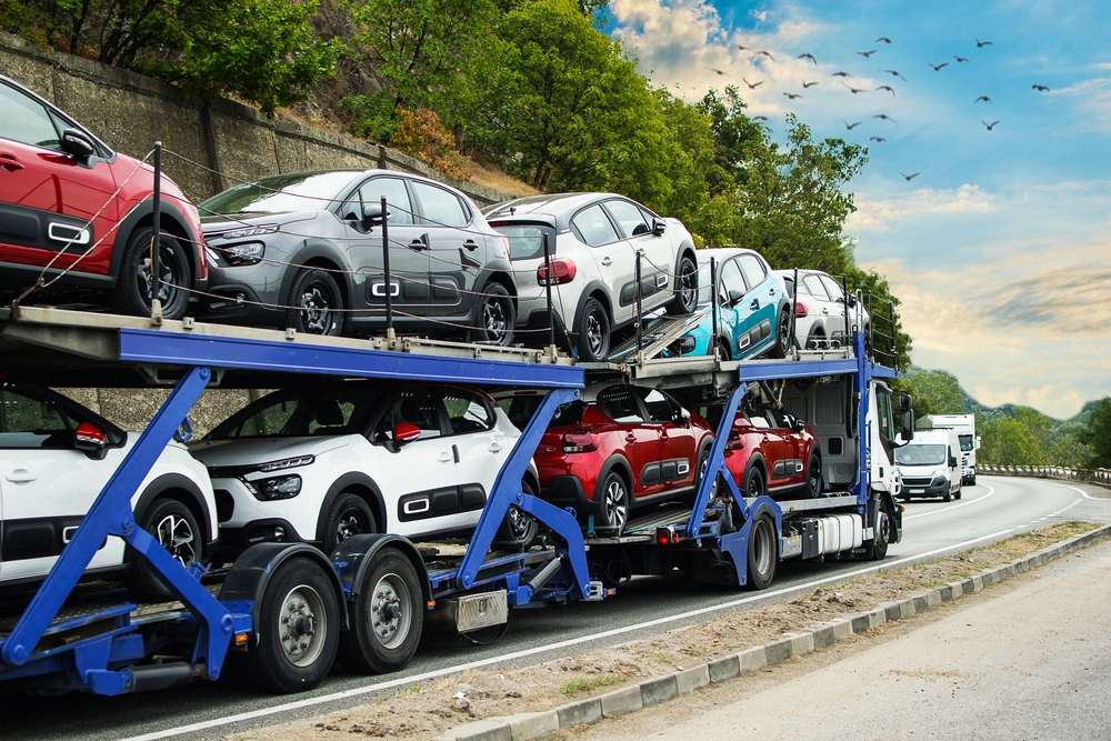 a truck loaded with several vehicles on a trailer