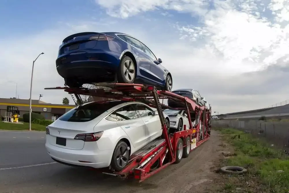 a truck delivering tesla vehicles